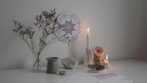 Altar espiritual com vela acesa, cristais, flores secas e elementos de meditação em ambiente sereno para práticas de manifestação e conexão interior.