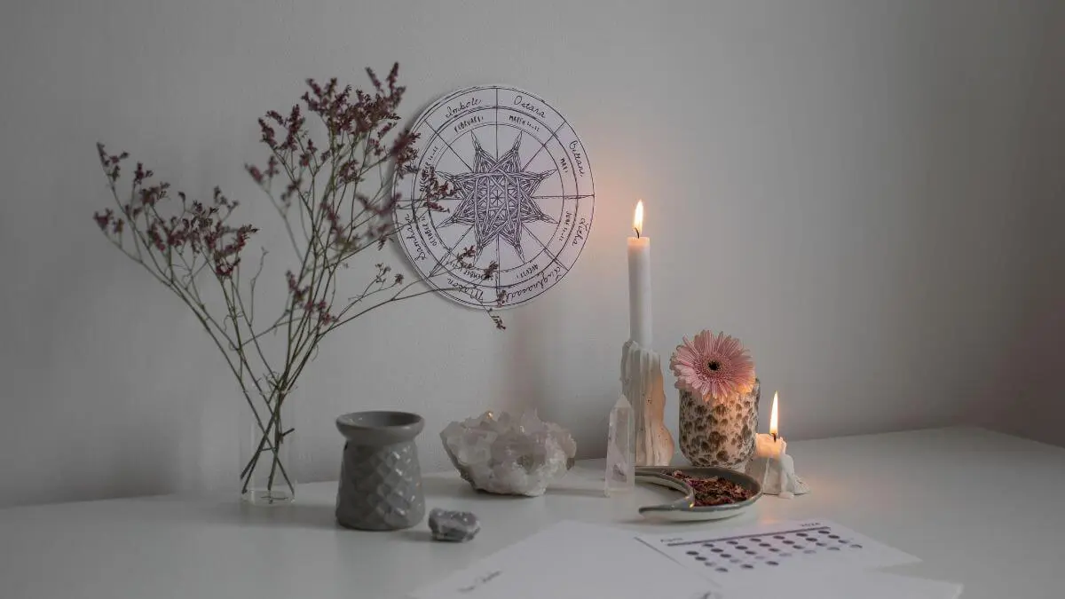 Altar espiritual com vela acesa, cristais, flores secas e elementos de meditação em ambiente sereno para práticas de manifestação e conexão interior.