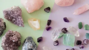 Cristais de ametista, quartzo-rosa, quartzo transparente e pedras verdes organizados sobre fundo em tons pastel.