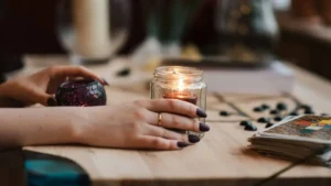 VELA ACESA COM CHAMA DOURADA REPRESENTANDO RITUAL DE MANIFESTAÇÃO ESPIRITUAL