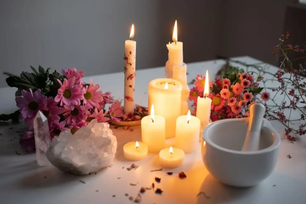 Velas acesas cercadas por cristais, flores e elementos de altar espiritual, criando um ambiente de meditação, manifestação e conexão com a espiritualidade.