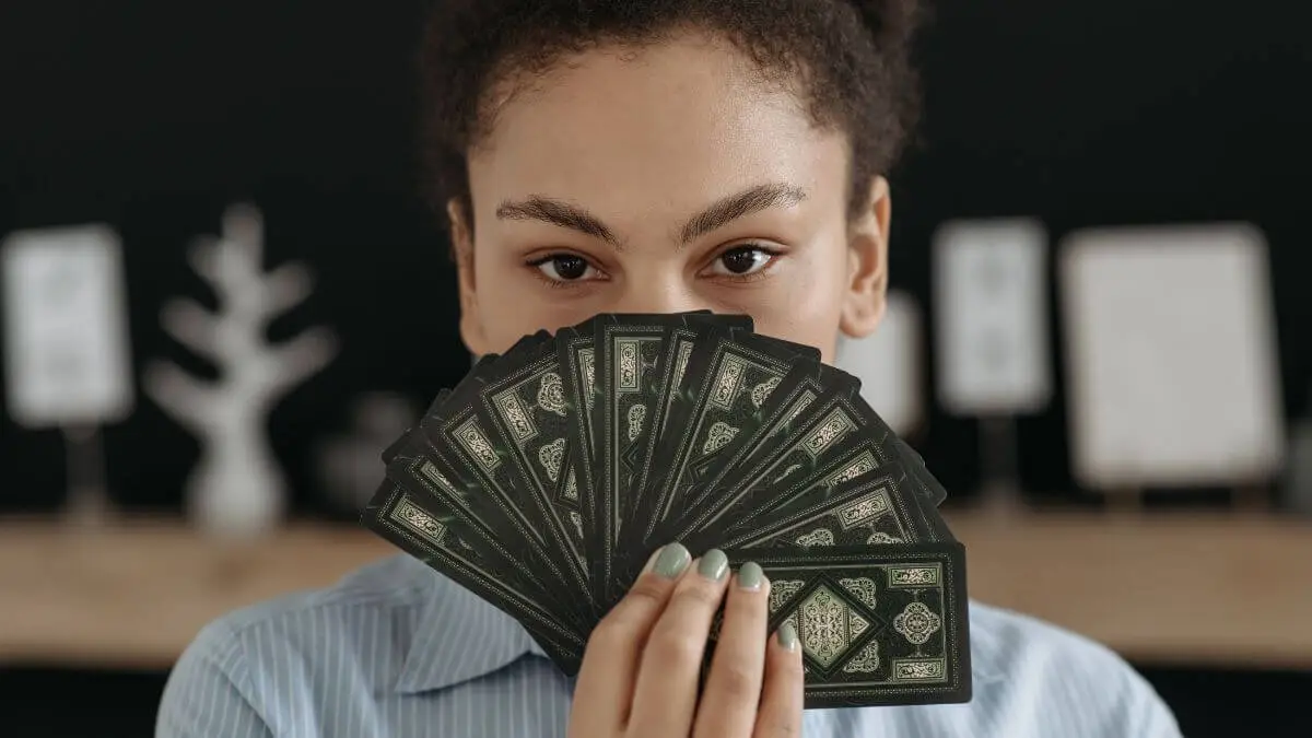 Mulher segurando cartas de Tarô em artigo sobre A Imperatriz
