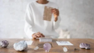 Pessoa realizando uma tiragem de tarô sobre mesa com cristais e esfera de ametista